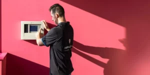 Technicus installeert brandcentrale in moderne kantoor voor branddetectie en alarmsysteem